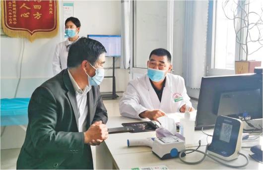 东营市河口区新建村卫生室家庭医生李景峰（右）正在对患者进行问诊。（□记者李丽报道）