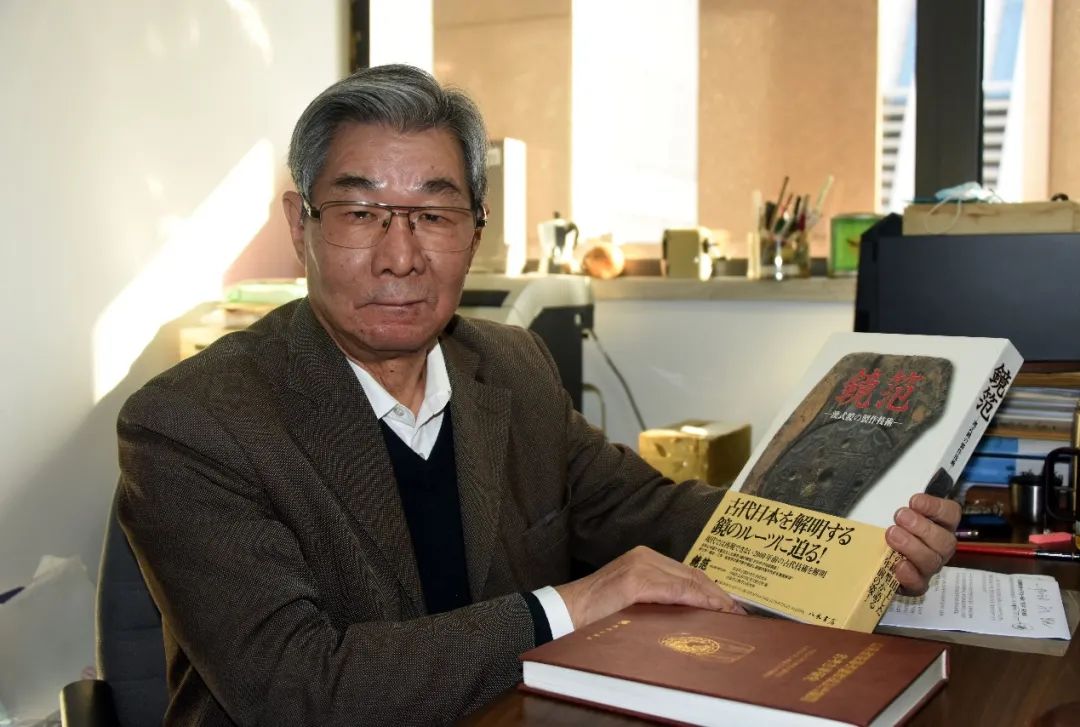 白云翔教授在北京办公室展示、介绍中日考古合作研究成果《镜范》日文版论著。中新社记者孙自法 摄