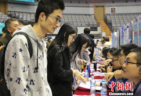 学生带着个人简历前来参加双选会，与招聘单位进行沟通交流。　赵晓 摄