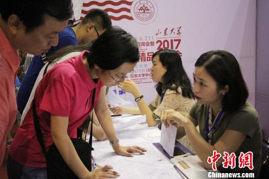 家长在高校招生处咨询了解学校的学科门类、专业设置、录取计划等信息。　赵晓 摄