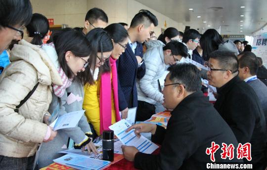 学生将个人简历交给用人单位的招聘人员，请他们查看。　赵晓 摄
