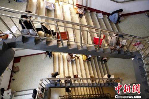 图为考研生坐在楼梯上专心背诵。孙宏瑗 摄 点击进入下一页