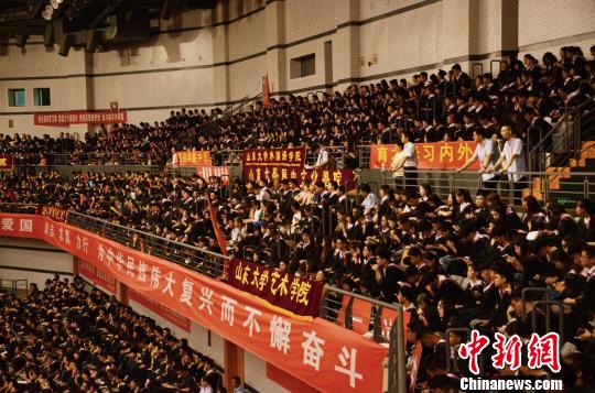 图为数千名身着学士服的本科毕业生端坐在场馆内，认真聆听校长和各级校友的寄语。　郝学娟 摄
