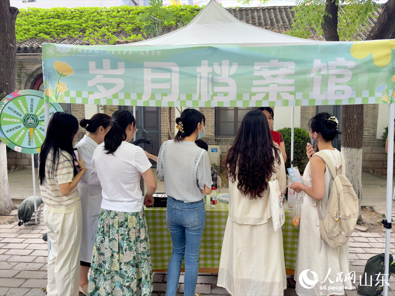 “岁月档案馆”摊位前,同学们踊跃答题。人民网 庄润泽摄