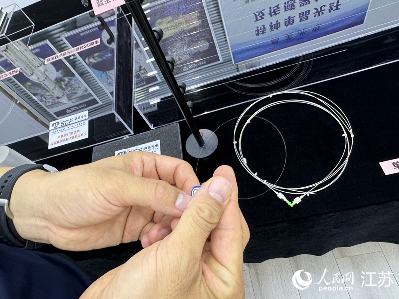 技术员展示直径22微米单晶光纤,粗细仅有头发丝的四分之一。人民网 杨维琼摄
