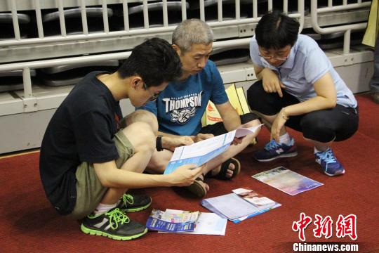 考生和家长在高考招生咨询会现场查看高校各方面信息。　赵晓 摄