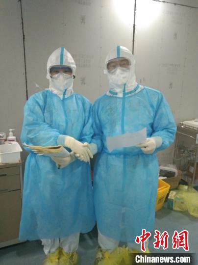 山东第四批支援湖北医疗队队员、山东大学齐鲁医院肝病科主治医师高帅与同事互相鼓劲加油。　山东大学齐鲁医院供图 摄